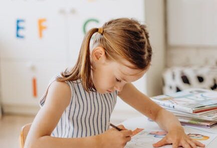 A young girl focused on coloring a book in a primary classroom setting, enhancing learning.